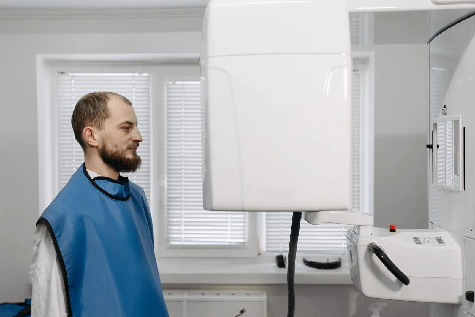 A patient in a lead apron at an upright x-ray unit.