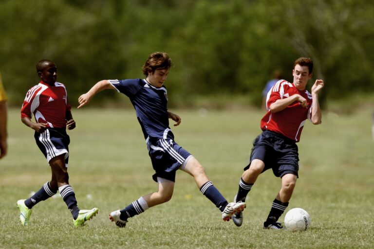 three men playing soccer